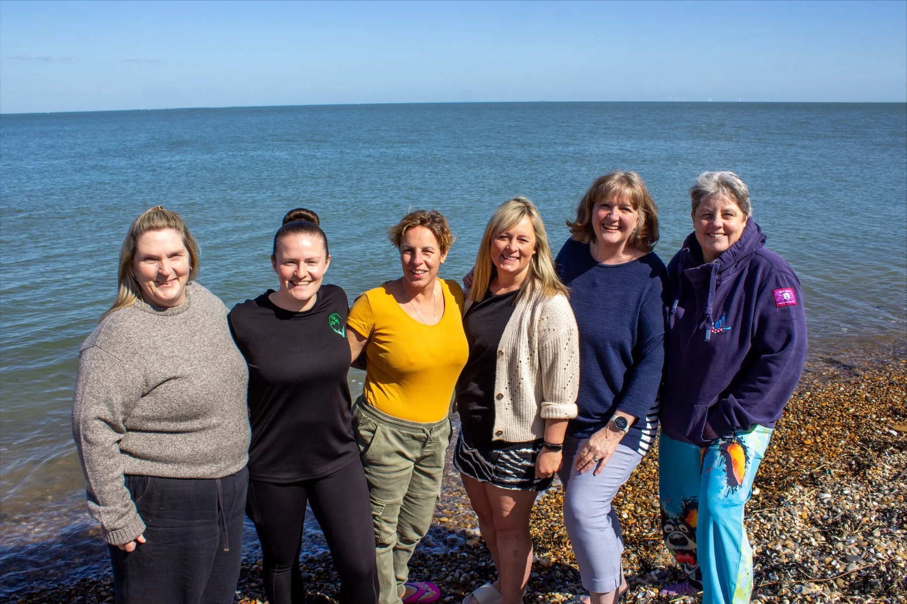 The six Channel Champions standing together beside the English Channel