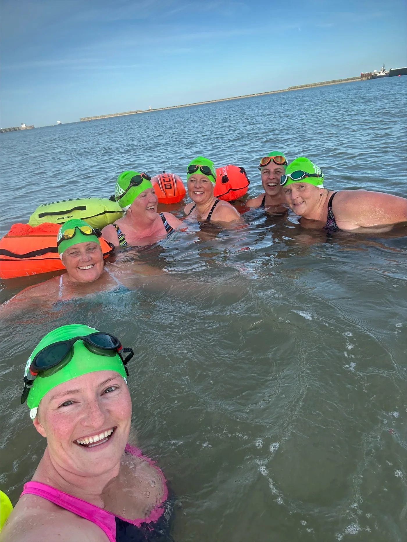 The Channel Champions smiling together during an open-water training swim
